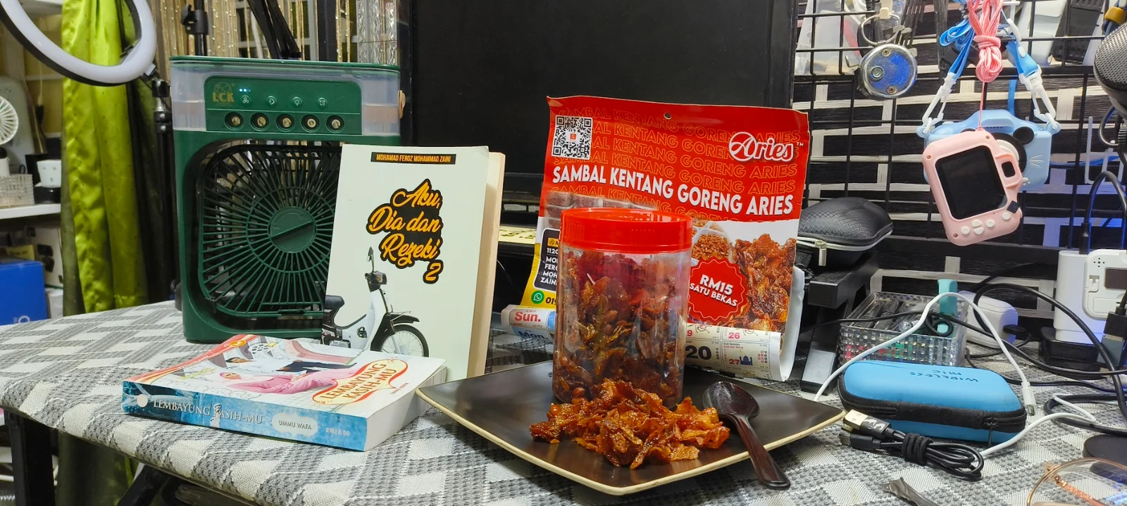 Sambal kentang goreng dalam balang di atas meja bersama buku dan setup workspace
