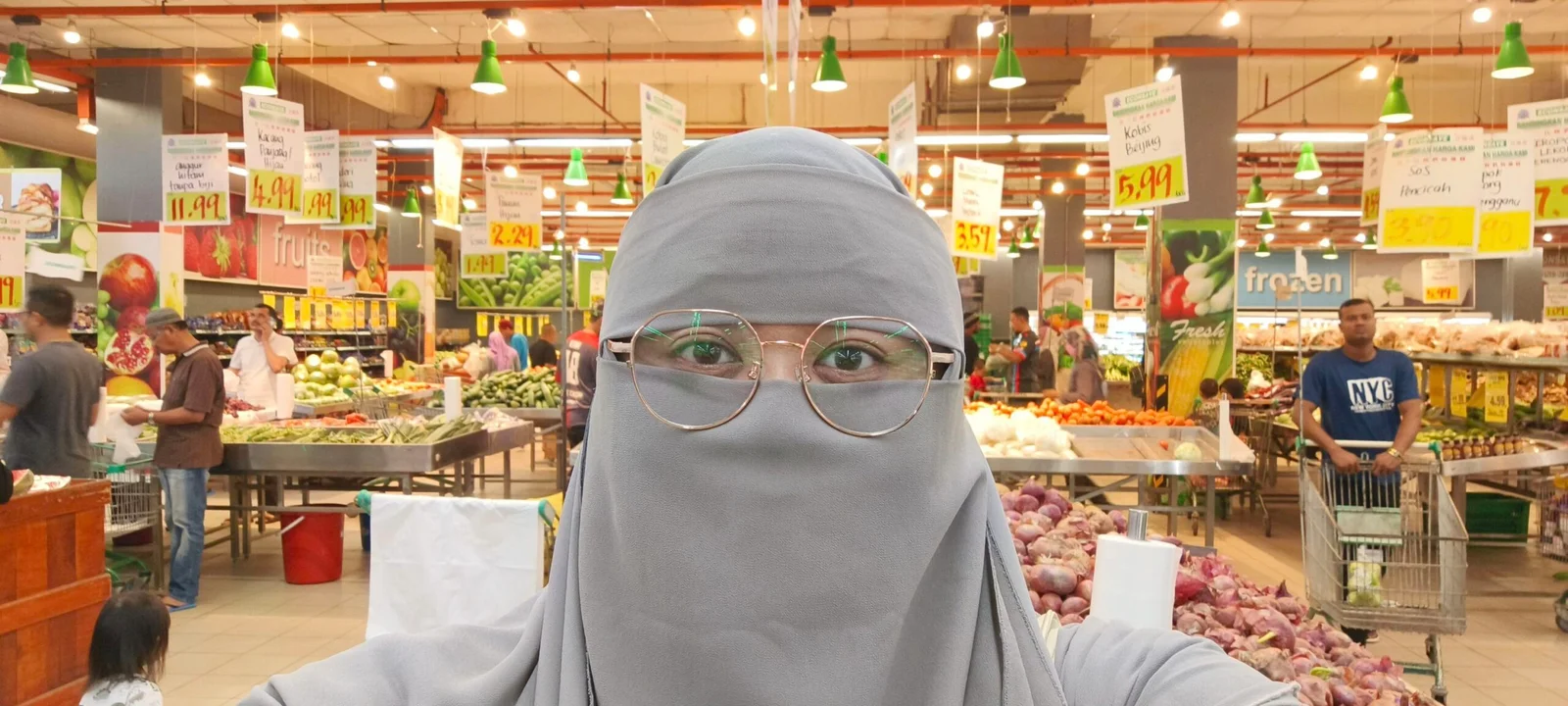 Wanita berniqab berselfie di pasar raya bahagian sayur sambil membeli barang dapur pada waktu pagi